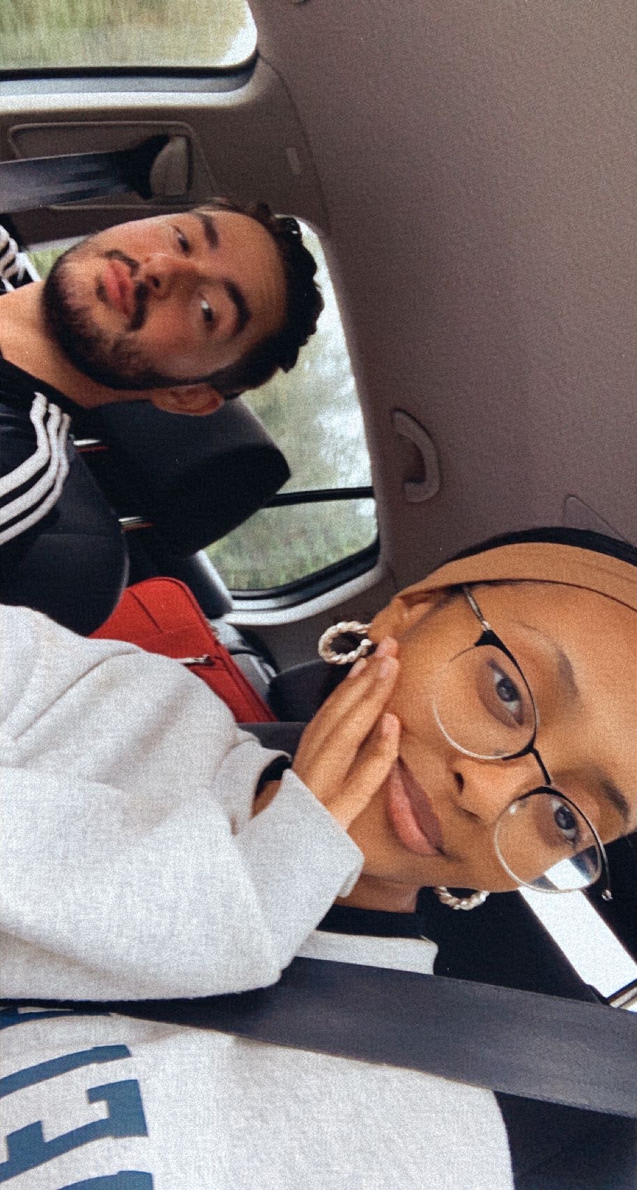 A tilted selfie of two friends inside a car